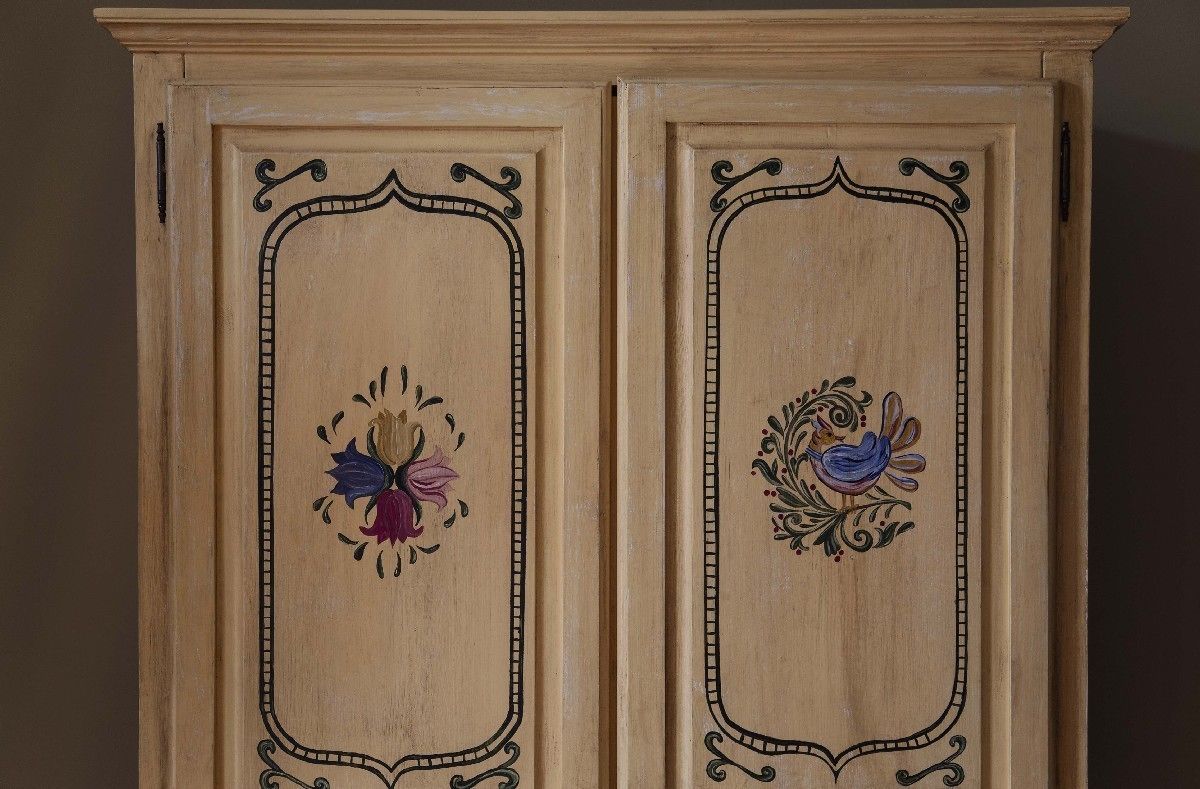 A wooden cabinet with ornate floral designs and a classic, elegant style.