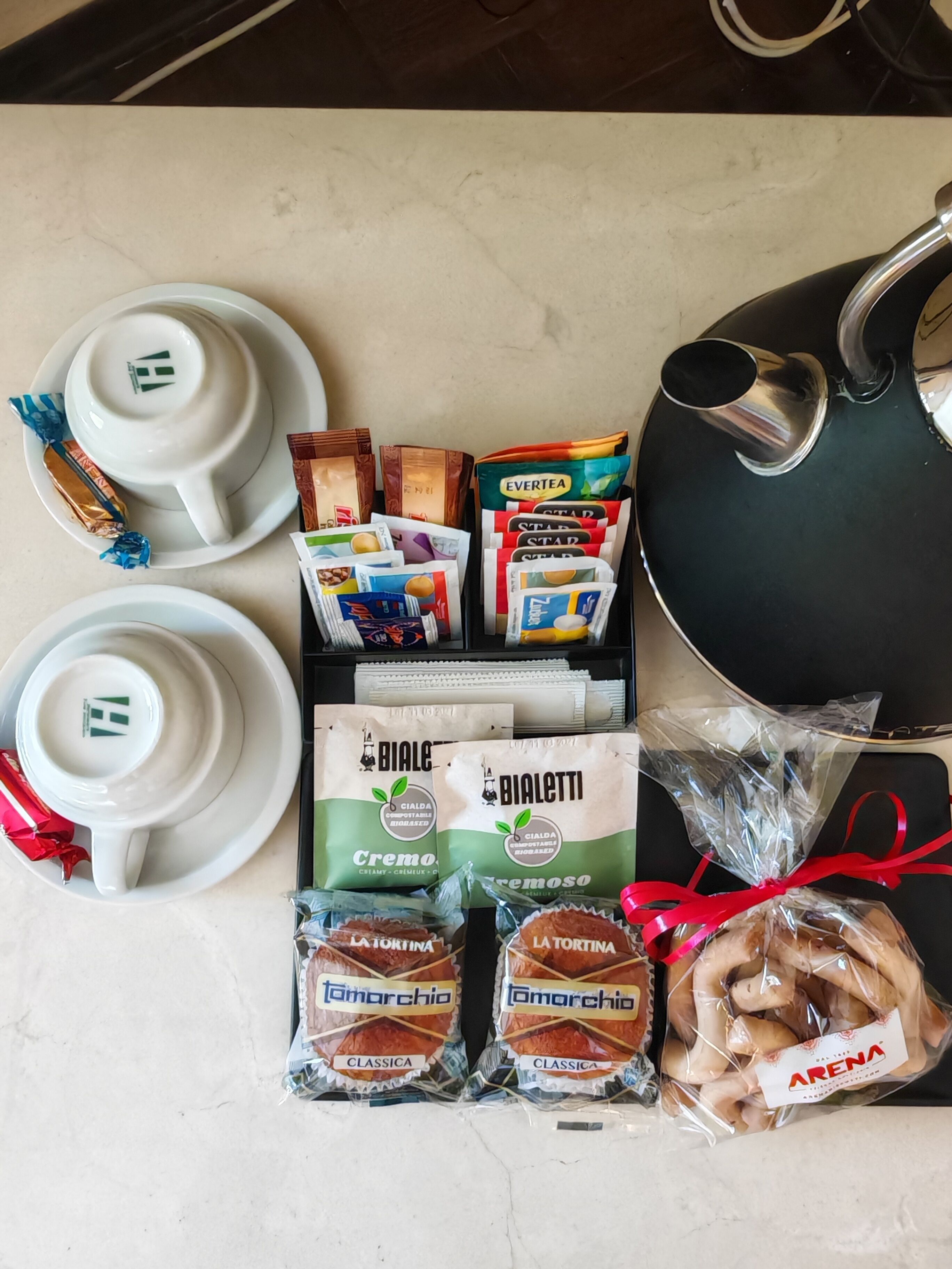 A table with various food items and a kettle.