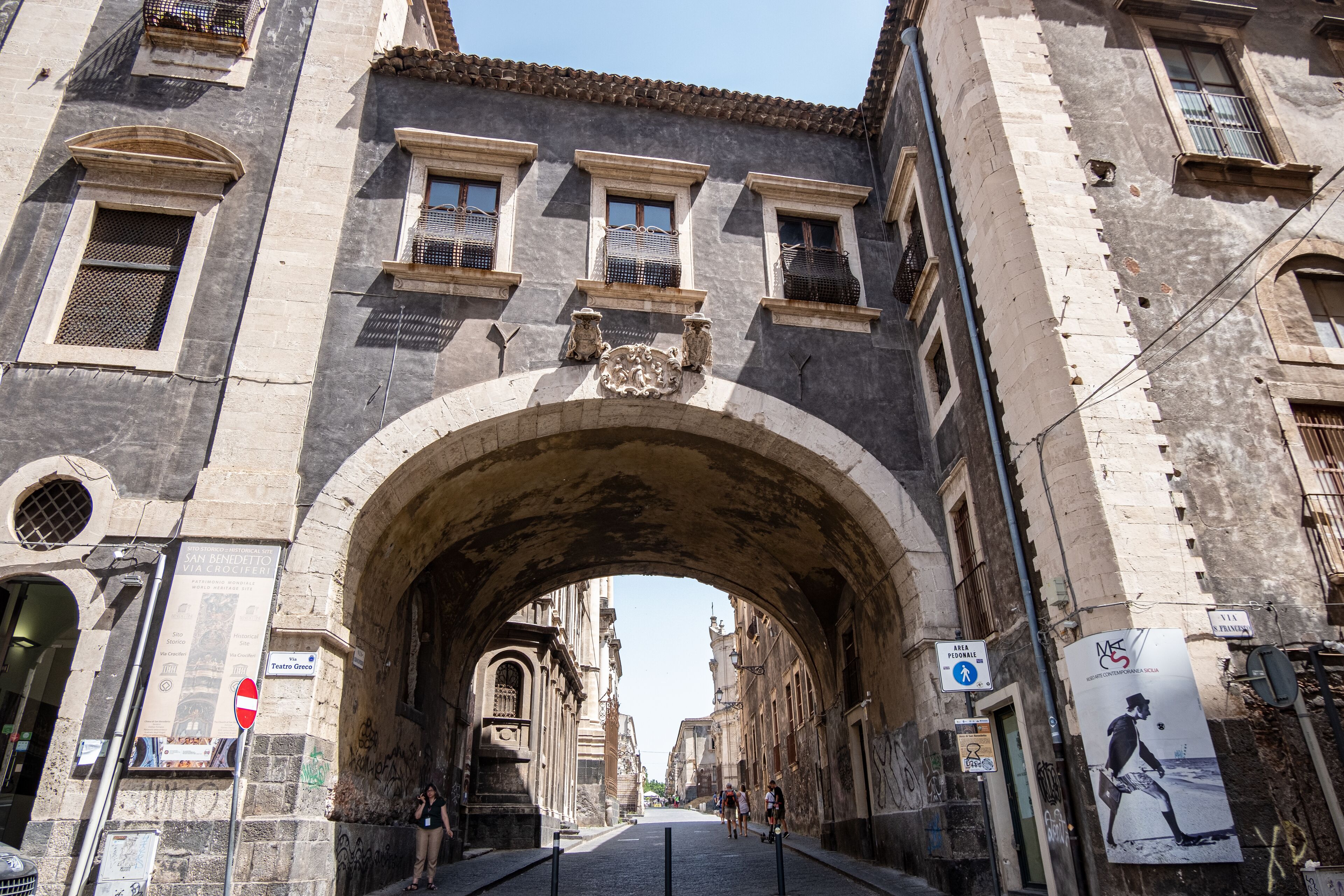 An arched stone bridge in a historic city center.