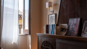 Una habitación con un armario de madera, una lámpara y libros en una estantería.