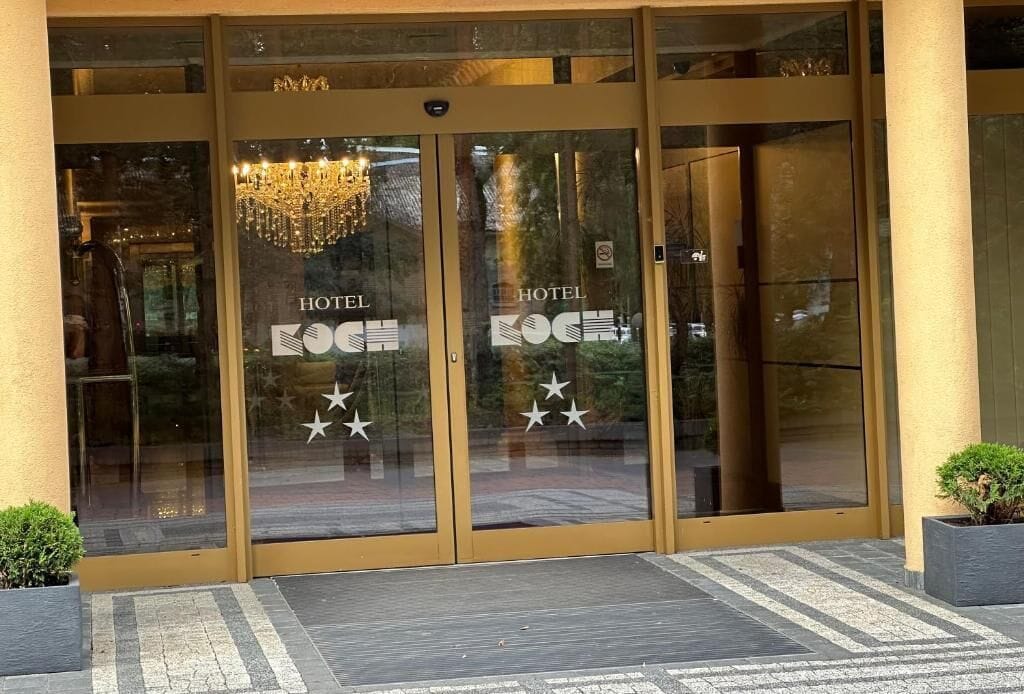 A hotel entrance with glass doors, a chandelier, and a star logo.
