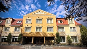 Un hotel de varios pisos con fachada simétrica, ventanas grandes y una entrada central.