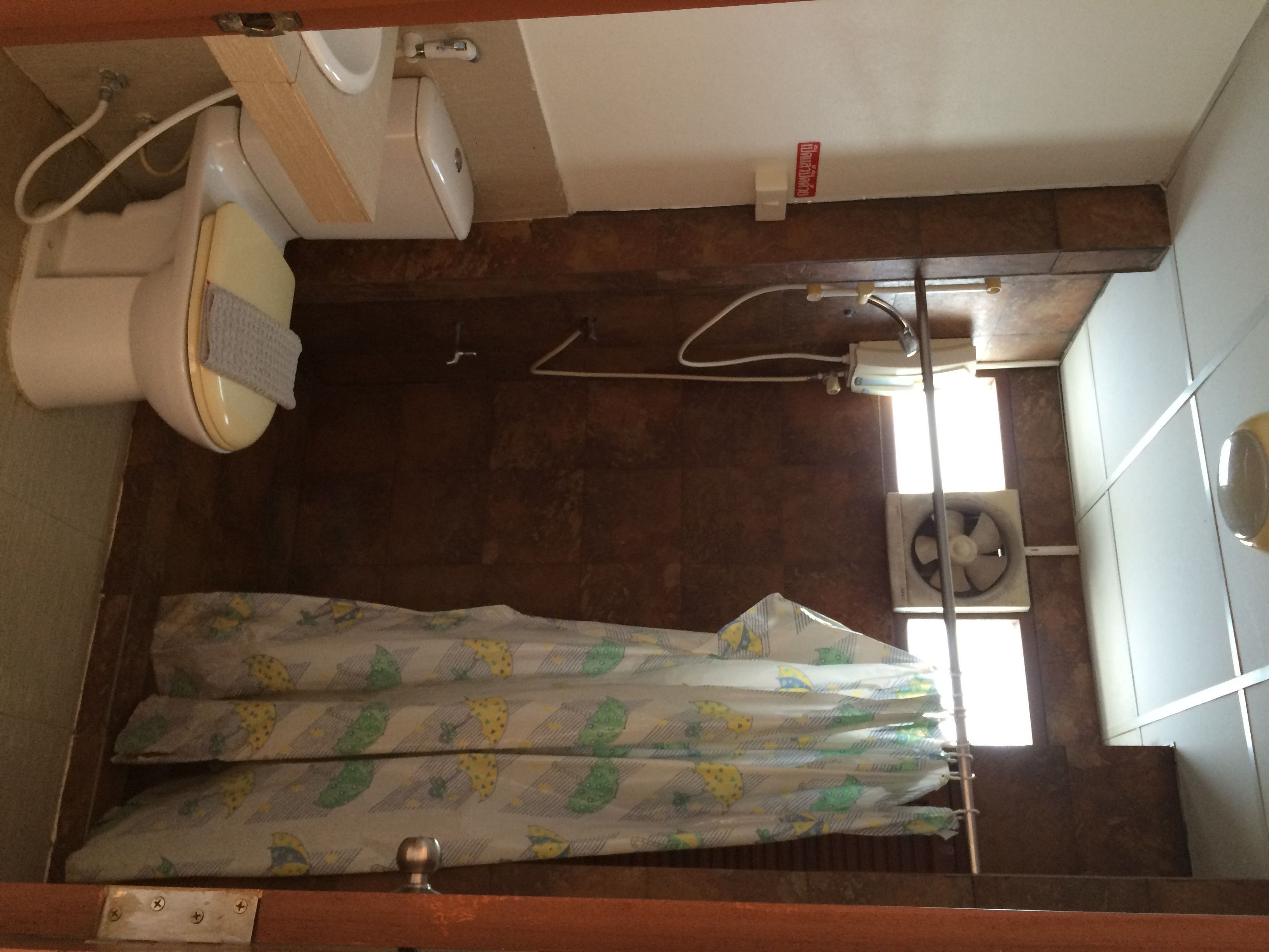 Een badkamer met toilet, bidet en een douchecabine met gordijn.