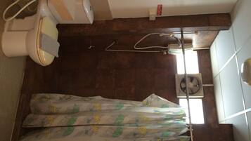 Een badkamer met toilet, bidet en een douchecabine met gordijn.