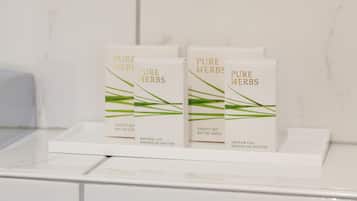 A display of Pure Herbs shower caps on a white tray in a bathroom.