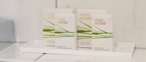 A display of Pure Herbs shower caps on a white tray in a bathroom.