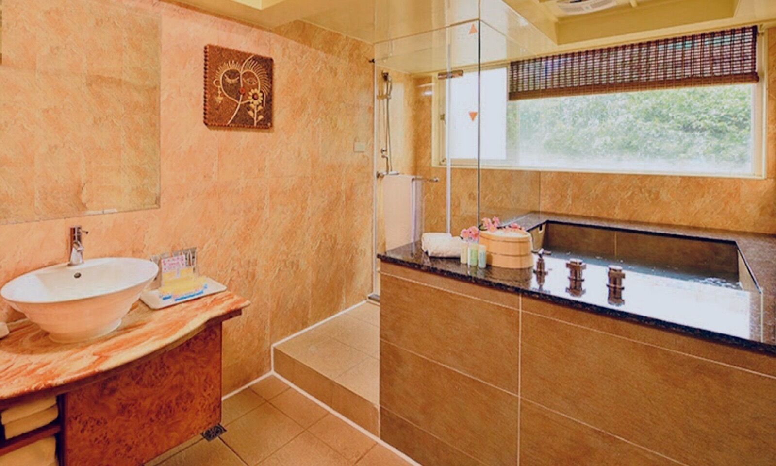 A bathroom with a large sink, a mirror, and a window with a view of greenery.