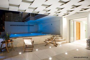 Una piscina al aire libre, sillones reclinables de piscina