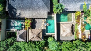 A rooftop pool area with multiple pools, surrounded by lush greenery and tropical plants. - Temuku Ubud Villas (Ubud)