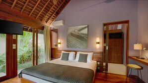 Um quarto espaçoso com uma cama grande, piso de madeira, TV e vista para o verde lá fora.