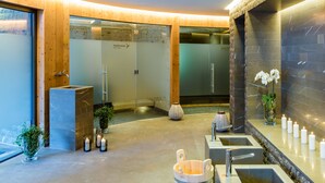 A spa area with a sauna, multiple sinks, and candles. - The Alpina Mountain Resort  (Tschiertschen)