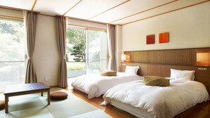 A hotel room with two beds, a small table, and a view of greenery through the window. - Satoyama no Kyujitsu Kyoto Keburikawa (Kameoka)