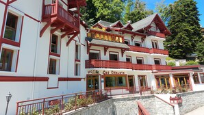 A traditional chalet-style hotel with multiple balconies and a stone facade.