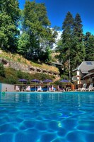 Una piscina al aire libre de temporada, sombrillas