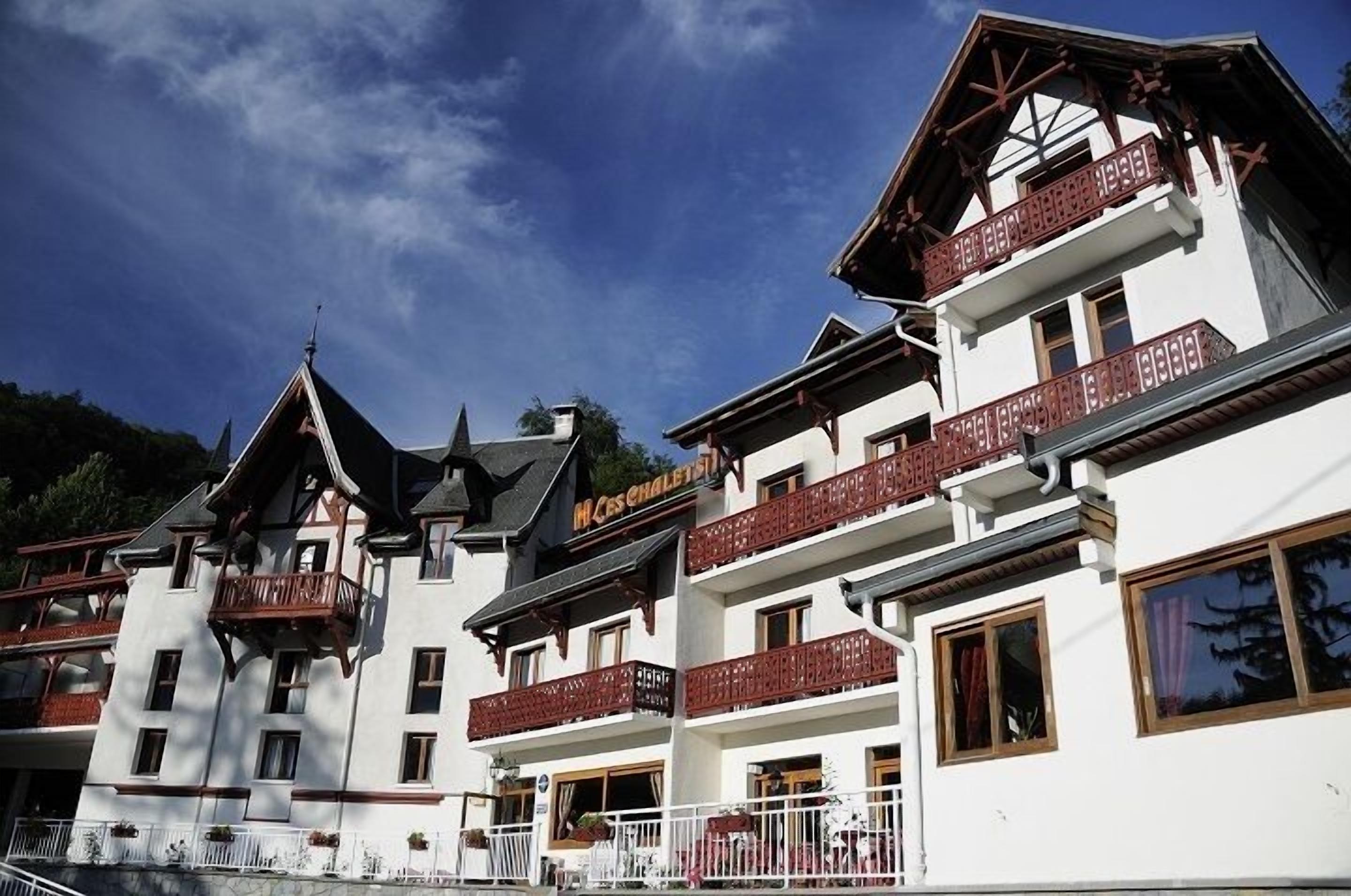 A multi-story hotel with balconies and a sign indicating it is a hotel.