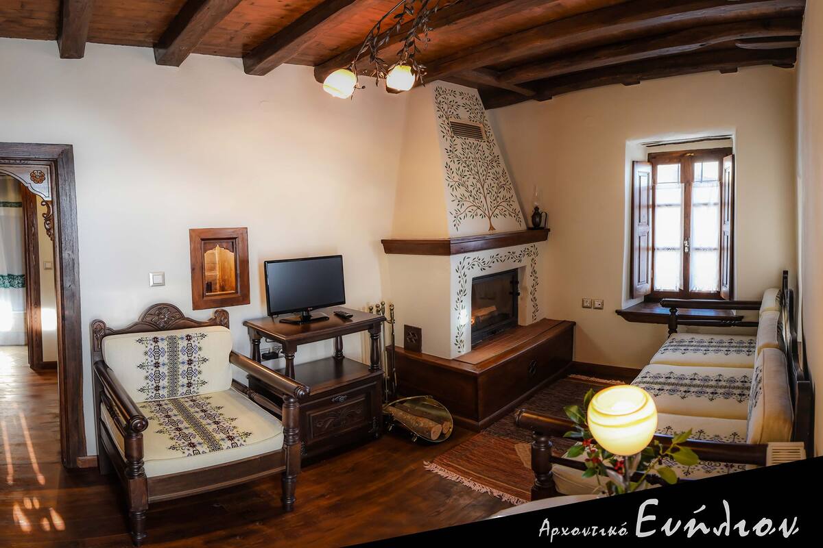 Una sala de estar acogedora con chimenea, muebles de madera y televisor.