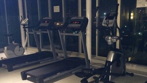 Ein Fitnessraum mit Laufbändern, Crosstrainern und einem Ergometer.