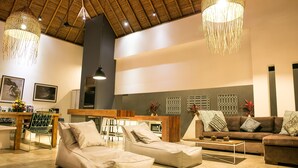 A spacious living area with a high ceiling, a dining area, and a sofa set. - Villa Turtle (Seminyak)