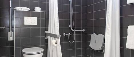 Uma casa de banho moderna com sanita, chuveiro e porta-toalhas.