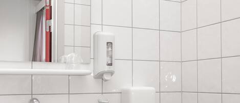 Un baño con lavamanos, espejo y retrete blancos.