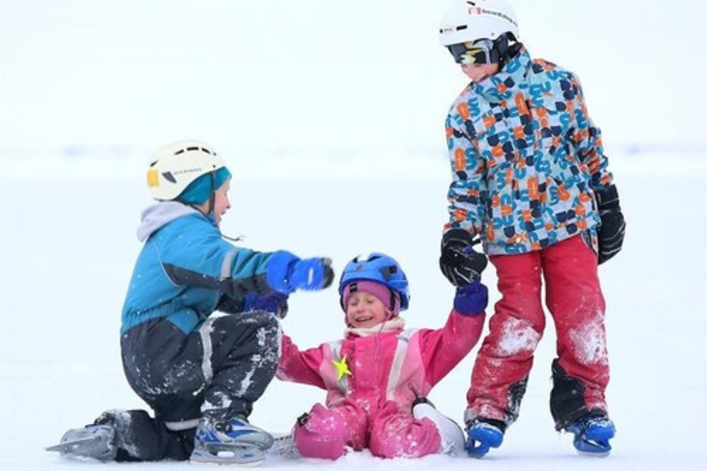 Een besneeuwd landschap met drie personen in winterkleding.