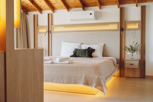 Un dormitorio moderno con cama, mesita de noche, aire acondicionado de pared y techo de madera.