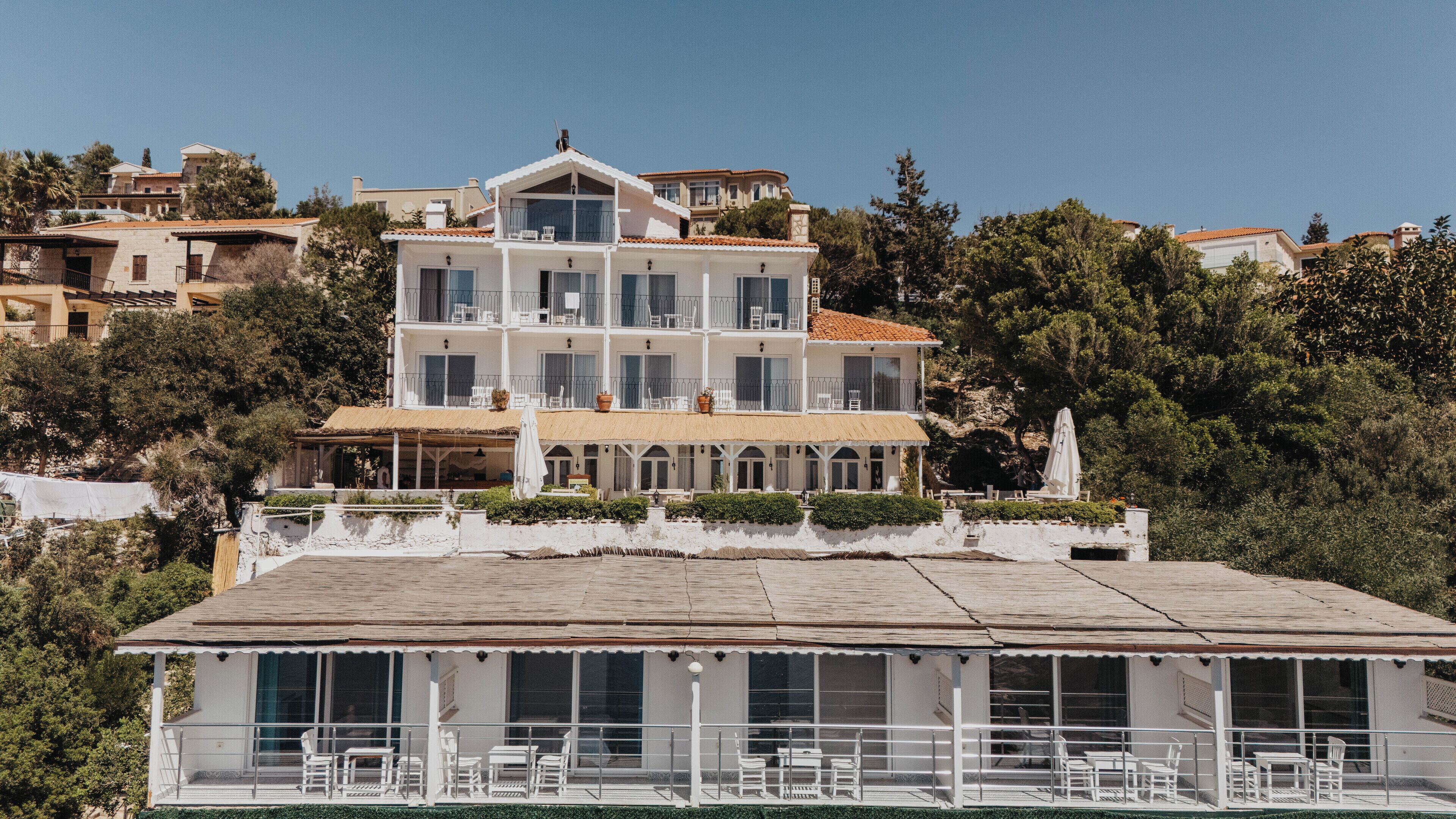 A multi-story hotel with a balcony and outdoor seating area.