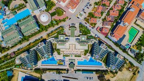 An aerial view of a hotel complex with multiple buildings, a central plaza, and surrounding greenery. - Royal Atlantis Spa & Resort (Manavgat)