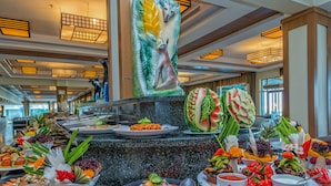 Un buffet proposant une variété de plats et agrémenté d’une grande sculpture décorative.