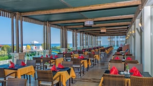 Un espace extérieur abrité, aménagé avec des tables et des chaises, offrant une vue panoramique.