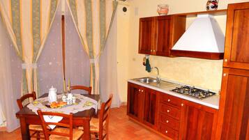 Una cocina funcional con muebles de madera, estufa a gas y pileta.