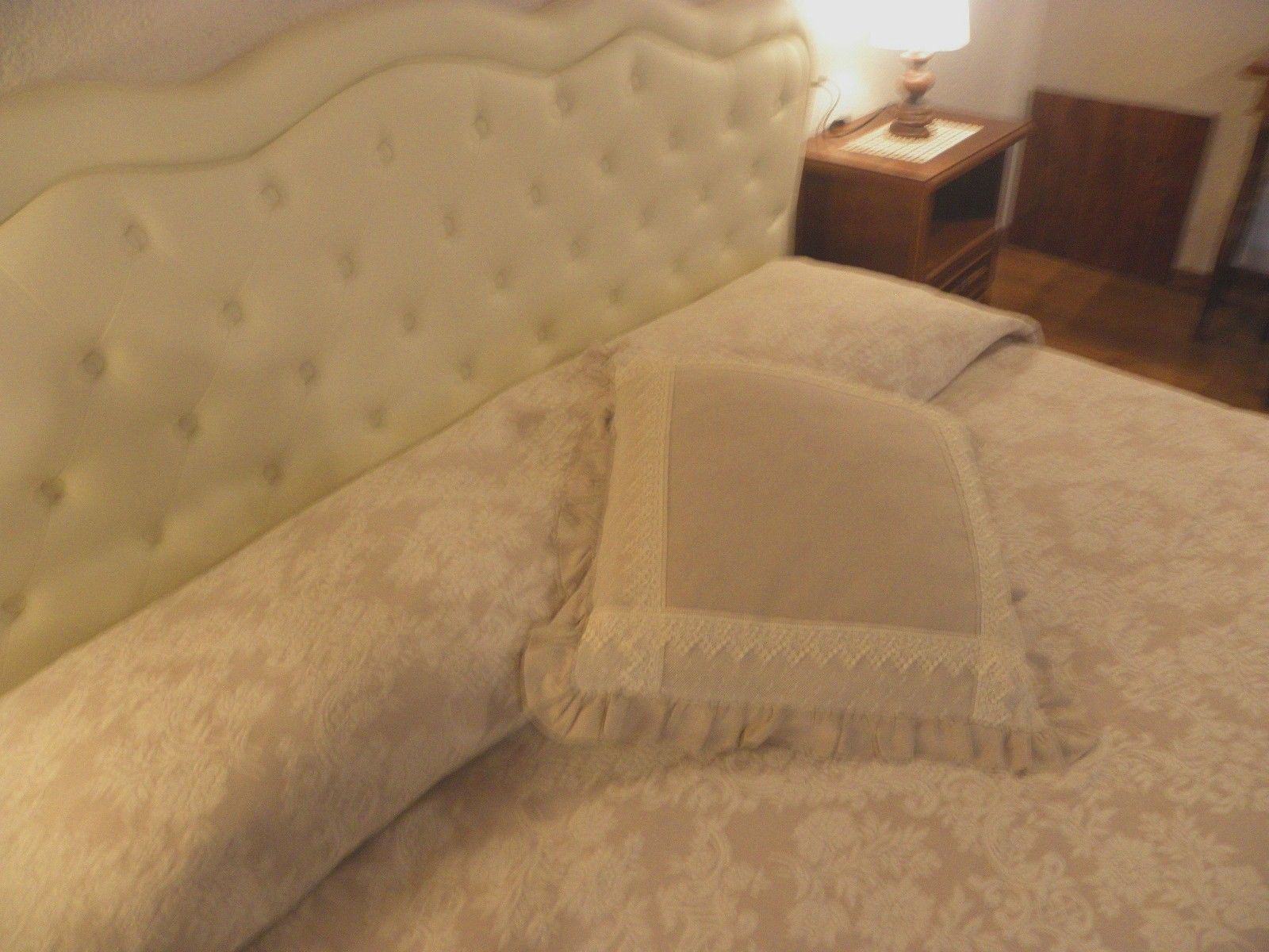 Ein Bett mit einem gesteppten Kopfteil und einer gemusterten Bettdecke.