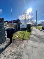 Señal de Pinewood Motels con un muro de piedra y un buzón a la izquierda.