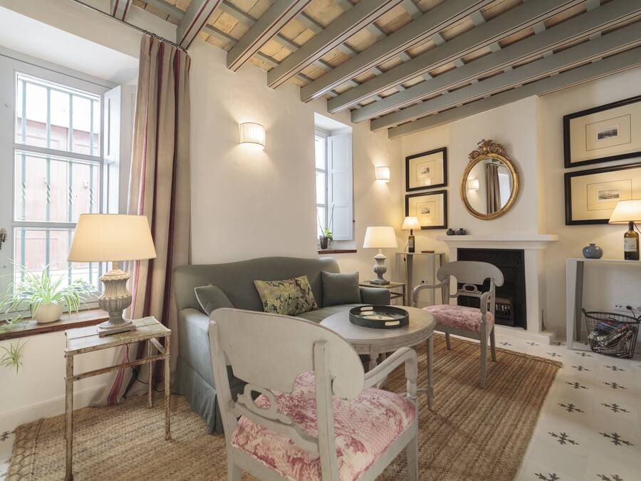 A cozy living room with a sofa, armchairs, a coffee table, and a fireplace.