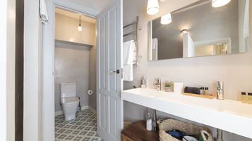 A bathroom with a white sink, mirror, and towel rack.