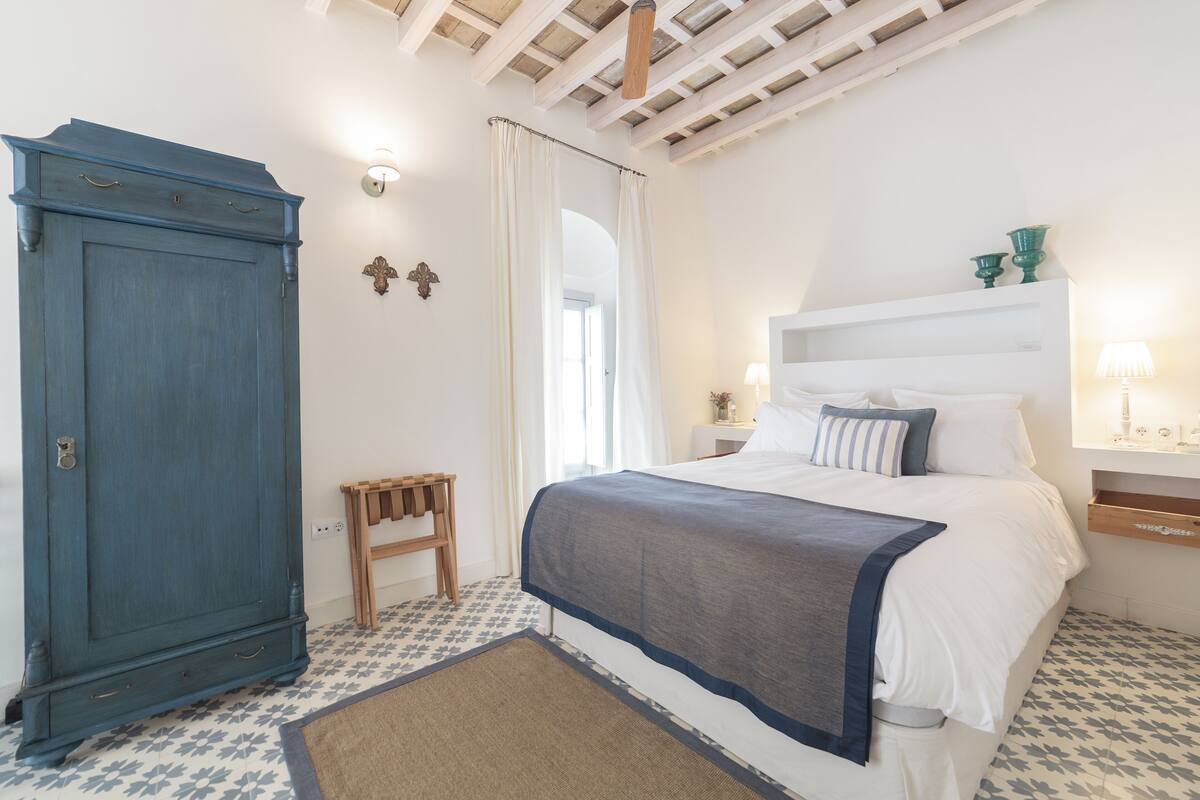 Une chambre à coucher comprenant un lit, une armoire, une table de chevet et une petite table.