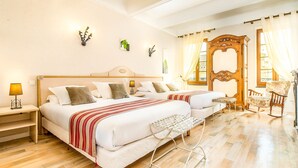 A hotel room with two beds, a wooden wardrobe, a rocking chair, and a small table. -  Logis Hôtel Restaurant Résidence (Nissan-lez-Enserune)
