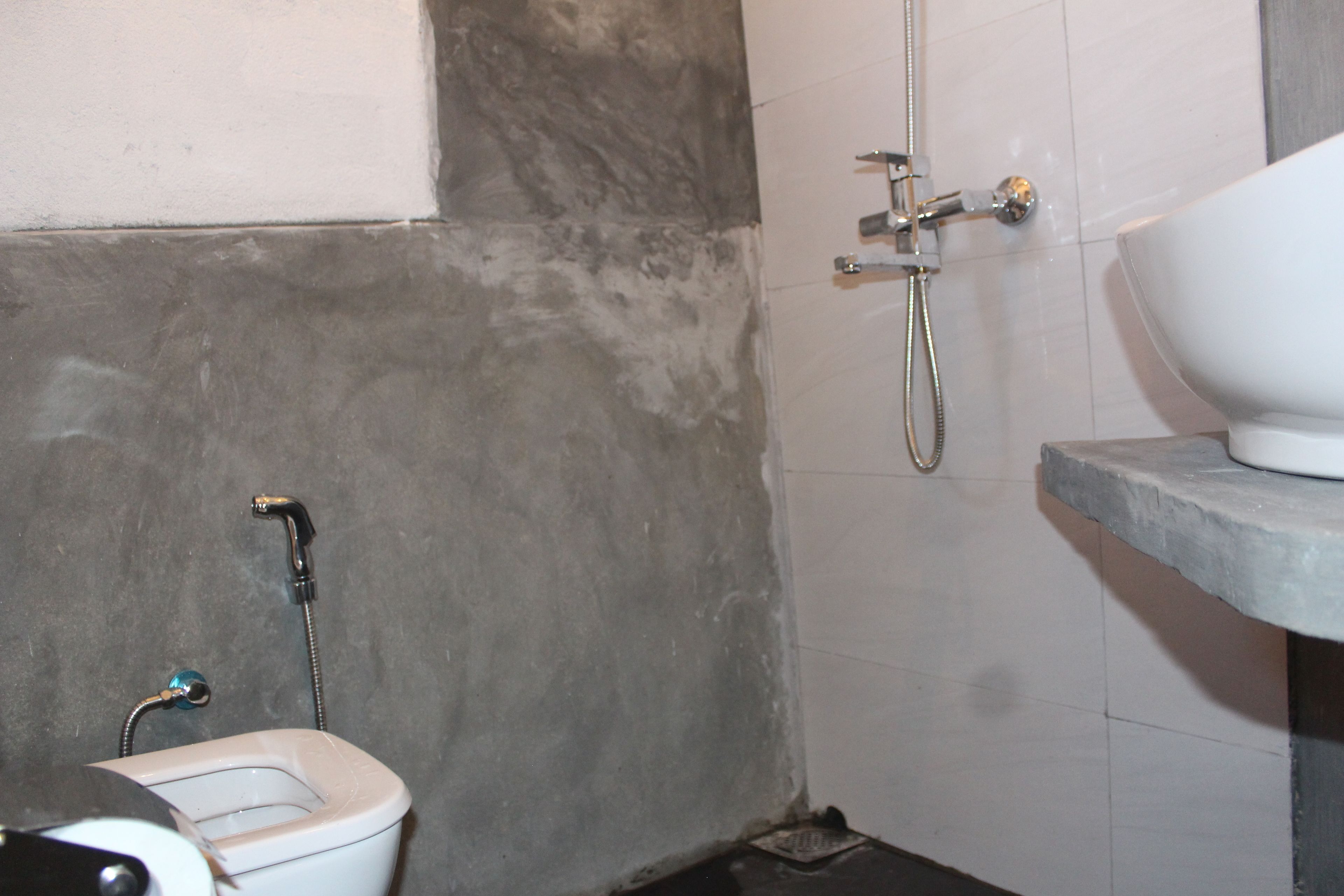 A bathroom with a toilet, a shower, and a sink.
