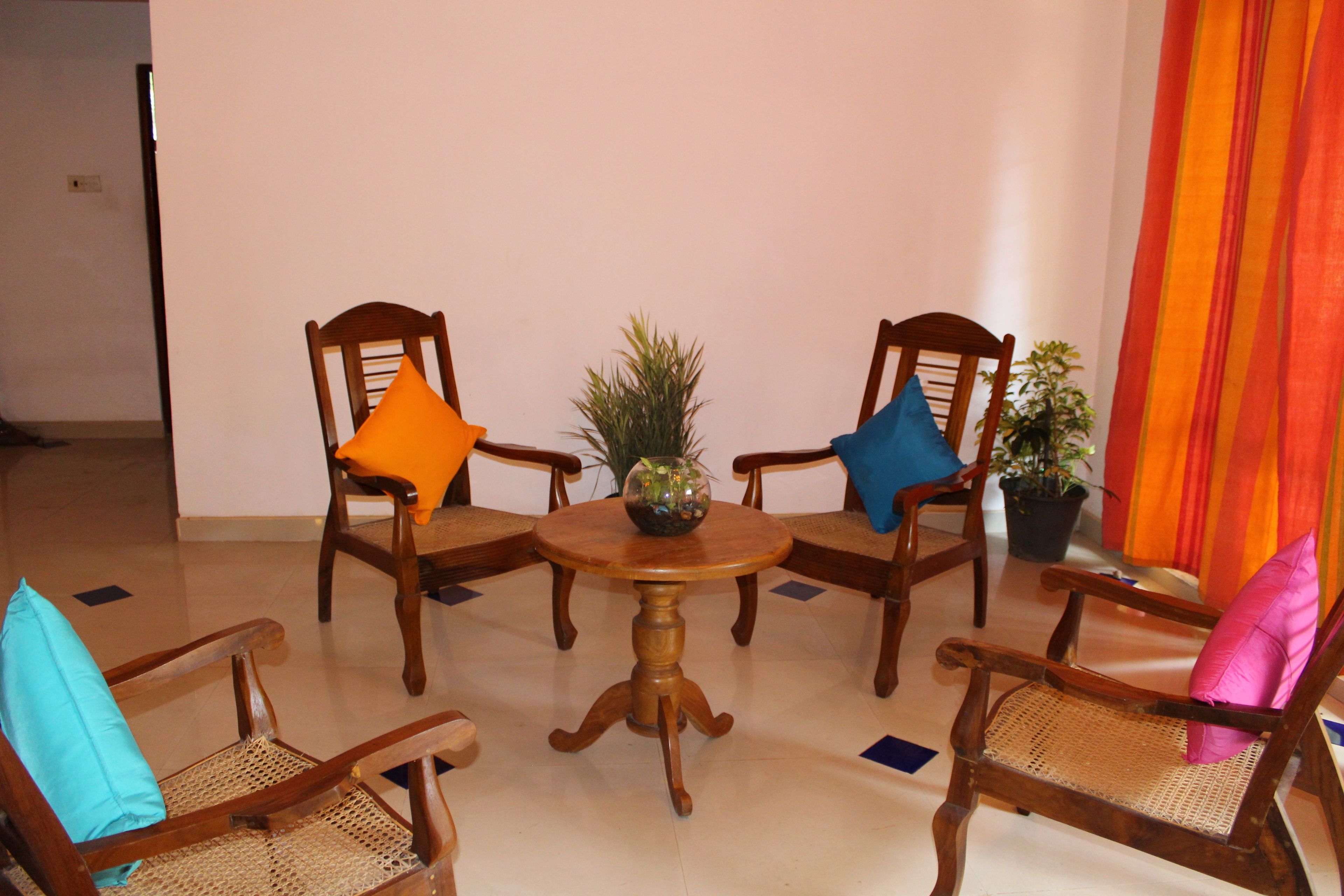 A dining area with a round wooden table surrounded by four wooden chairs with woven seats.