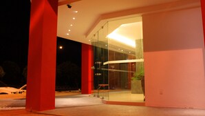 A modern building with a glass entrance and red structural elements. - Hotel Time Nilai (Nilai)
