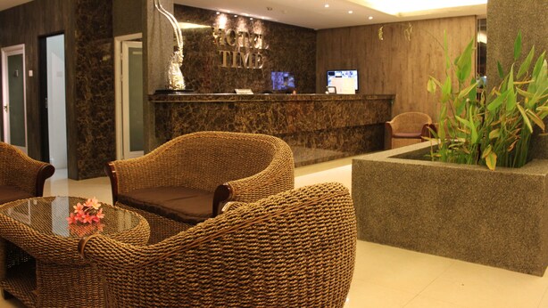 A hotel reception area with wicker furniture, a reception desk, and a plant. - Hotel Time Nilai (Nilai)