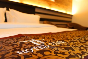 Un lit d’hôtel avec une couvre-lit à motifs et des oreillers.