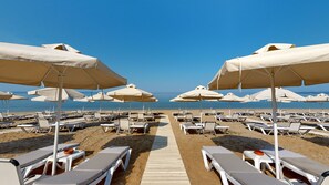 Accommodatie ligt op het strand, ligstoelen, parasols
