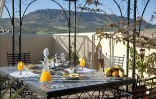 Mesa posta para o café da manhã, com vista para montanhas.