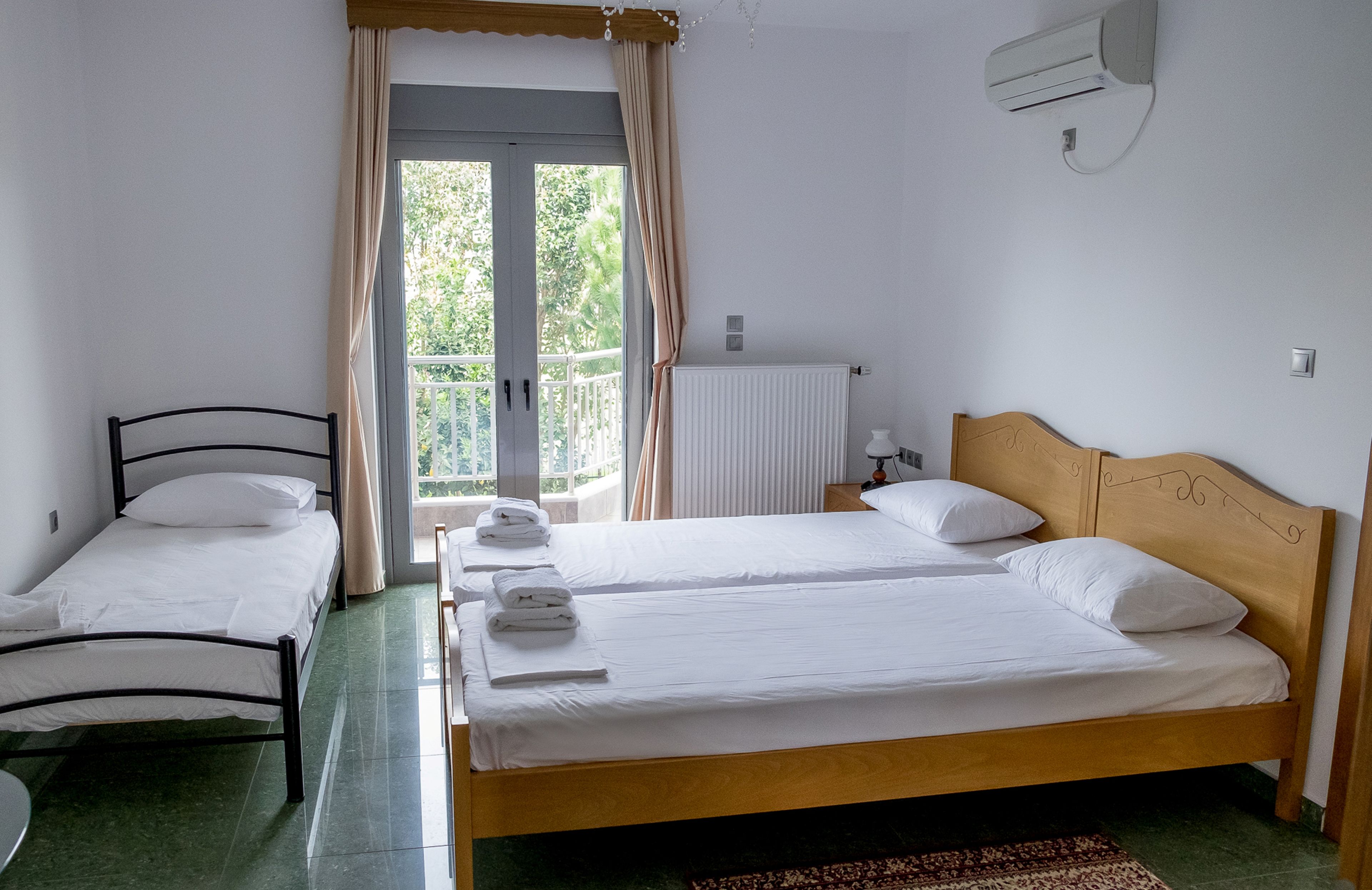 Una habitación con dos camas, un radiador y una ventana con cortinas.