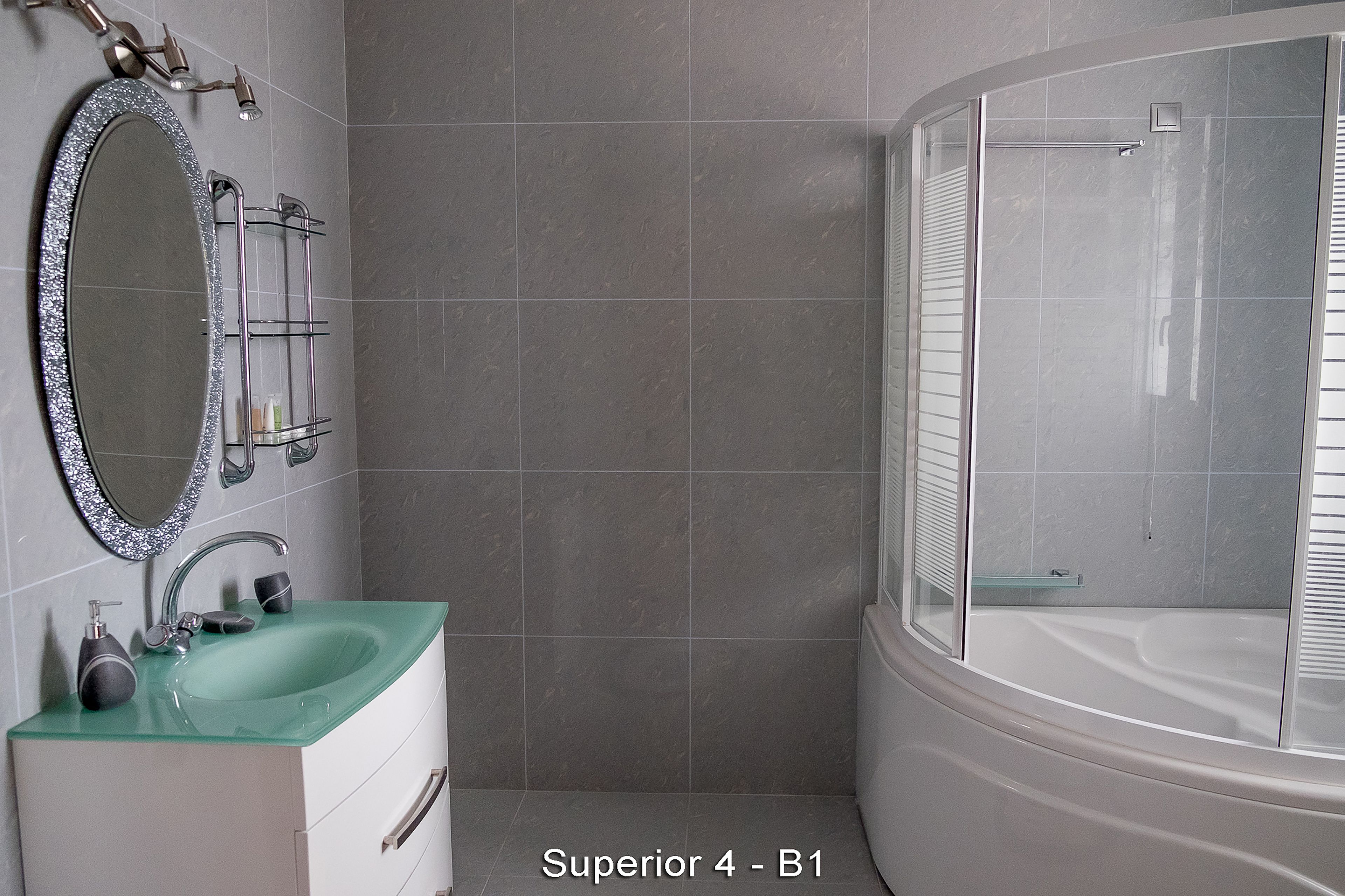 A bathroom with a glass-enclosed shower, a white bathtub, and a green sink with a mirror above it.