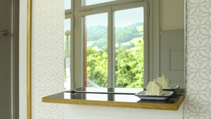 A kitchen counter with a window view of a green landscape. - Hotel Militärkantine (St. Gallen)