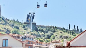 Un edificio con balcón y vista a un sistema de teleférico.