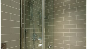 A modern shower with glass doors, a chrome showerhead, and a handheld showerhead. - Holiday Inn Express London - Ealing by IHG (London)