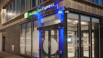 Eingangsbereich eines Holiday Inn Express Hotels mit automatischen Türen und einer Glasfassade.